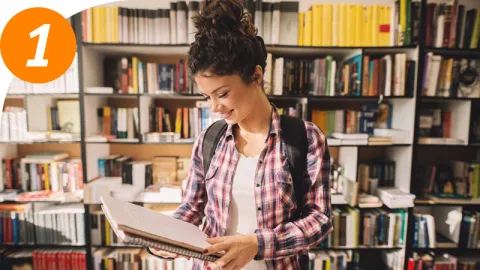 Person steht in Bibliothek | WINGS-Fernstudium